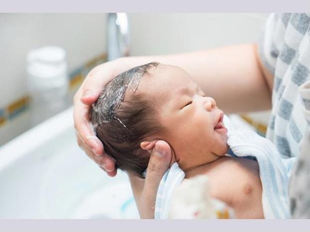 Làm ướt đầu bé, cho dầu gội xoa đều và sau đó rửa sạch ngay